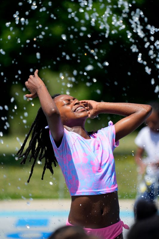 Malaya Anderson, 12, enjoys cool sprays from the splash pad at Madison Park at 9800 W. Glenda Ave. in Wauwatosa, Wisconsin, on July 1, 2026. Anderson and her sister were with their mother who brought the girls and children from Big Achiever's Daycare to cool off at the park. Extreme temperatures continued through the week in Milwaukee County and surrounding areas.