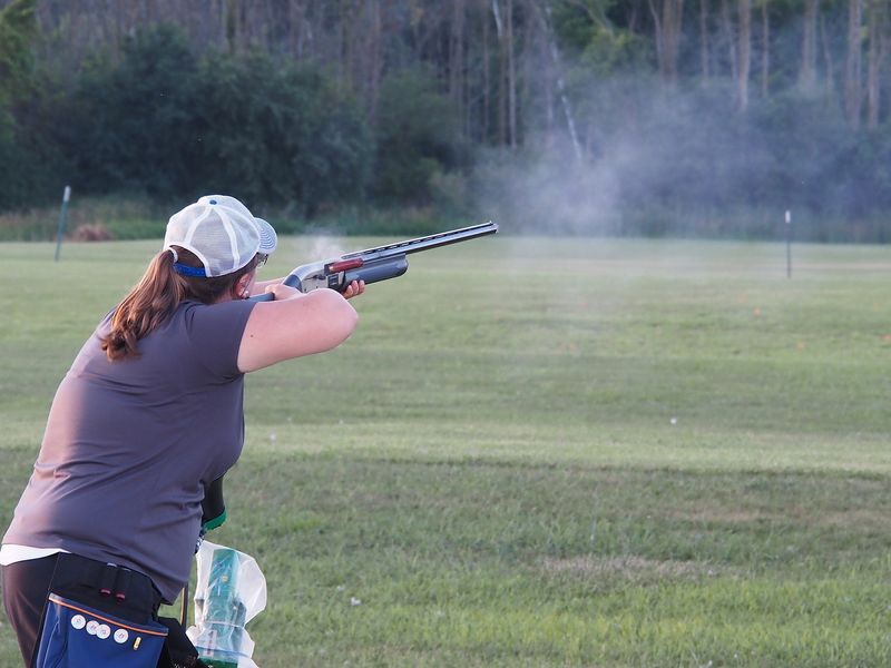 A spent shell is propelled from the ejection port and smoke bellows from the barrel as Brianna Sieracki of Manitowoc fires her shotgun during the Manitowoc Gun Club’s league competition Thursday, July 9, 2026. Sieracki shoots on the Carole’s Maids team.