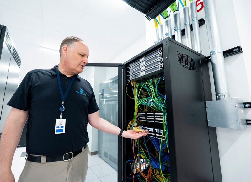 Ryan Brooks, CTO and general manager of Data Holdings, shows a switching and routing cabinet inside a data center suite at Data Holdings in Milwaukee, Wisconsin on June 23, 2026.