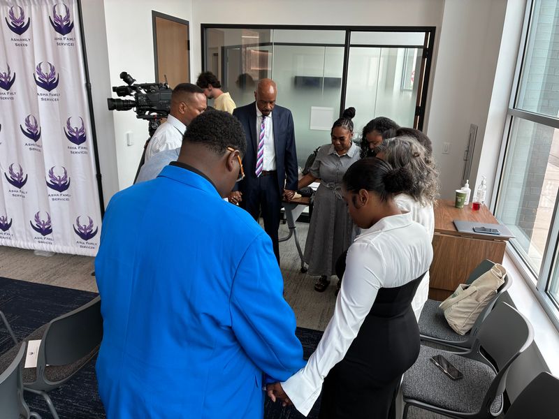 Community leaders pray before an event hosted by the Asha Project at the Marcia P. Coggs Health and Human Services Center in Milwaukee on Thursday, July 16. The Asha Project is expanding its men's programs amid a rise in deaths stemming from domestic violence incidents.