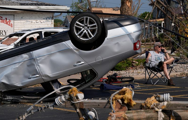 John Dobish sits next to his destroyed car in the parking lot of Manderfield’s Home Bakery following severe weather, including a tornado Monday, July 27, 2026, in Menasha, Wisconsin. Dan Powers/USA TODAY NETWORK-Wisconsin