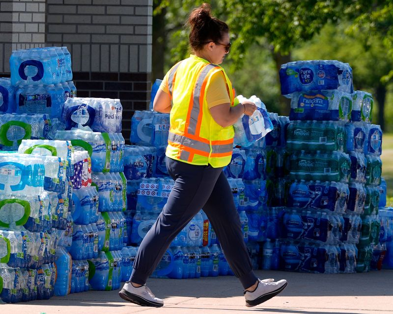 A volunteer loads donated water at the former University of Wisconsin-Oshkosh Fox Cities campus during day 3 of tornado clean-up in Menasha, Wisconsin on July 29, 2026. An estimated EF-3 tornado tore through the area on July 27. Wm. Glasheen USA TODAY NETWORK-Wisconsin