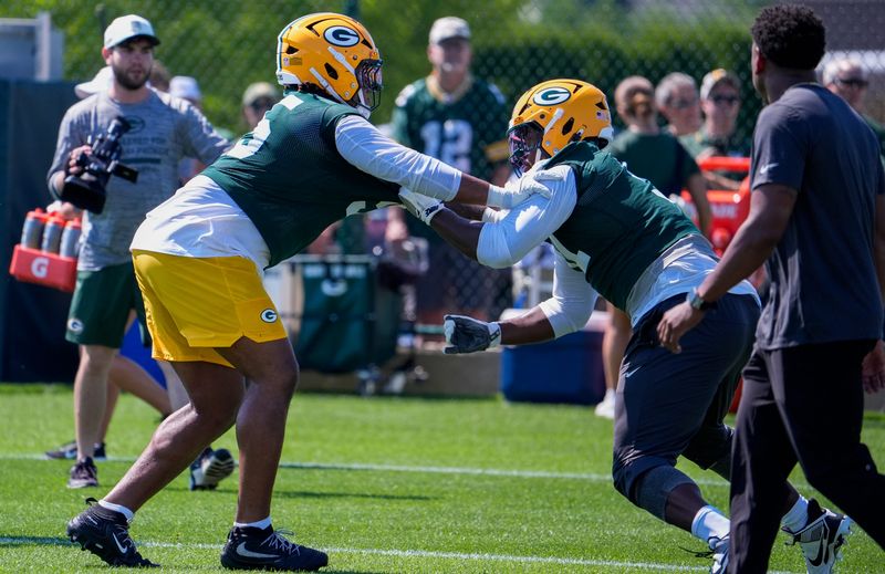 Green Bay Packers defensive linemen Devonte Wyatt, left, and Warren Brinson run through a drill during the first day of training camp.