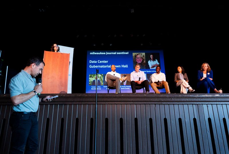 A Port Washington alderman Michael Beaster, left,  asks the Democratic gubernatorial candidates a question regarding protecting natural resources from large scale data center projects during the Milwaukee Journal Sentinel Data Center Gubernatorial Town Hall at the Turner Hall Ballroom in Milwaukee, Wisconsin on July 29, 2026.