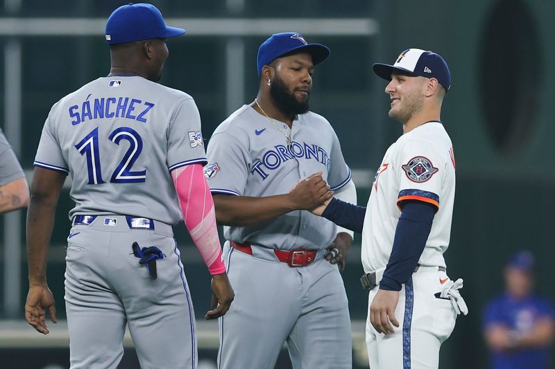New Houston Astros center fielder Daulton Varsho (18) greets Toronto Blue Jays first baseman Vladimir Guerrero Jr. (27) and left fielder Jesus Sanchez (12) before the game at Daikin Park.