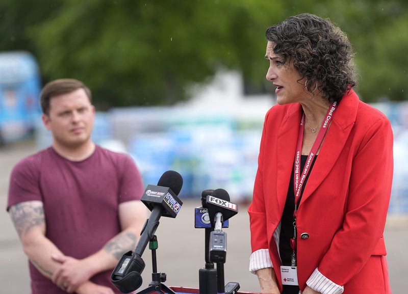 As Menasha mayor Austin Hammond looks on, Rebecca Rockhill, executive director Northeast Chapter Wisconsin Red Cross, speaks during a press conference providing information about Red Cross disaster assistance in Menasha, Wisconsin on Wednesday, August 5, 2026.