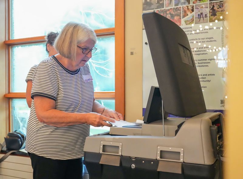 Poll worker Linda Babcock processes absentee ballots for the Wisconsin partisan primary election at the Sharon Lynne Wilson Center for the Arts polling station in Brookfield, Wisconsin, on Tuesday, August 11, 2026.
