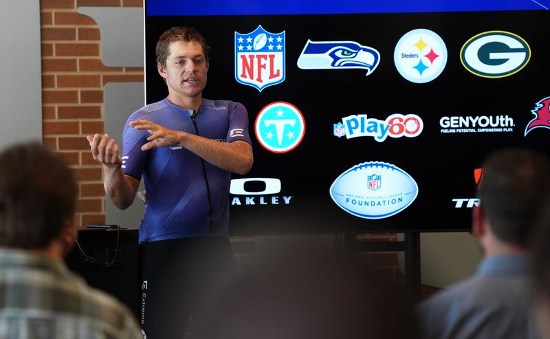 Endurance cyclist Bond Almand, who is riding his bike to every NFL stadium in 65 days, speaks about his journey while visiting Lambeau Field on Aug. 11 in Green Bay