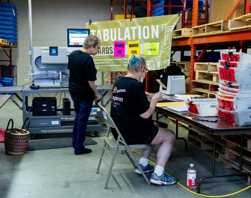 Election workers run absentee ballots through a tabulation machine at the Milwaukee central count in Milwaukee, Wisconsin on Aug. 11, 2026. J
