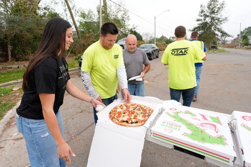 Luigis Pizza & Pasta manager Sarah Jaber, left, talks with DTak employees Thursday, August 13, 2026, in Menasha, Wisconsin. Luigis Pizza & Pasta was collaborating with Bob Karrmann, owner of Westgor Funeral Homes, to donate pizza and beverages to tornado relief volunteers.