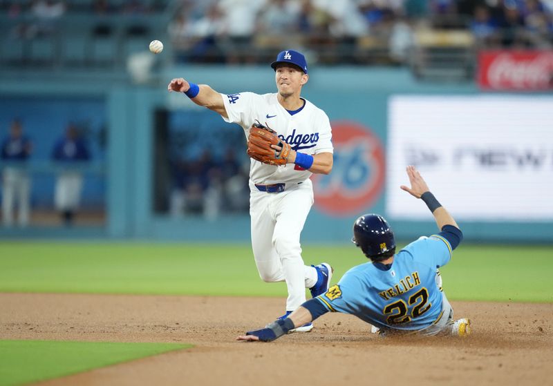 Aug 14, 2026; Los Angeles, California, USA;  Los Angeles Dodgers second baseman Tommy Edman (25) throws out Milwaukee Brewers designated hitter Christian Yelich (22)  at second base during the second inning at Dodger Stadium. Mandatory Credit: Kirby Lee-Imagn Images