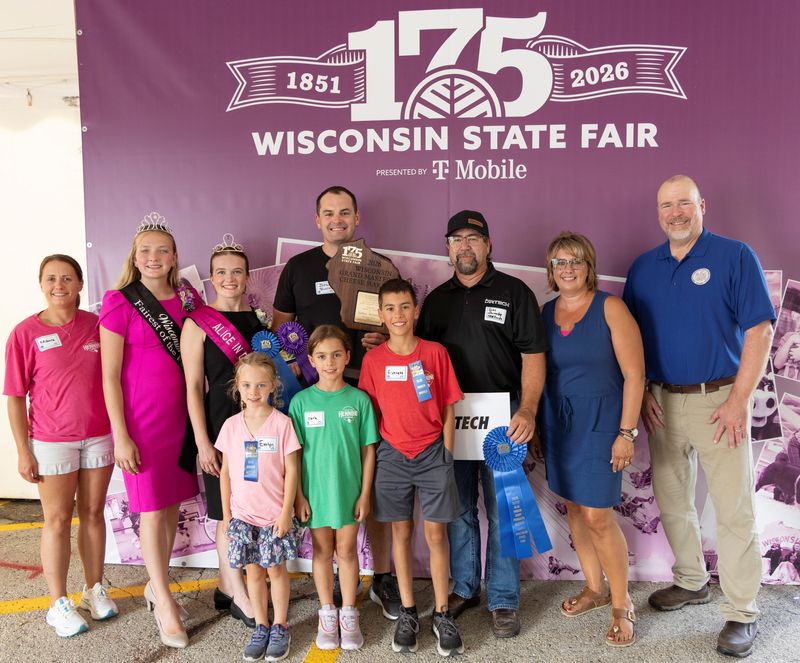 Joshua Henning of Henning Cheese, holding trophy, was named Grand Master Cheese Maker at the 2026 Wisconsin State Fair Blue Ribbon Dairy Products Auction on Aug. 13. His 18-month traditional waxed cheddar sold for $6,600 to DR Tech during the auction.