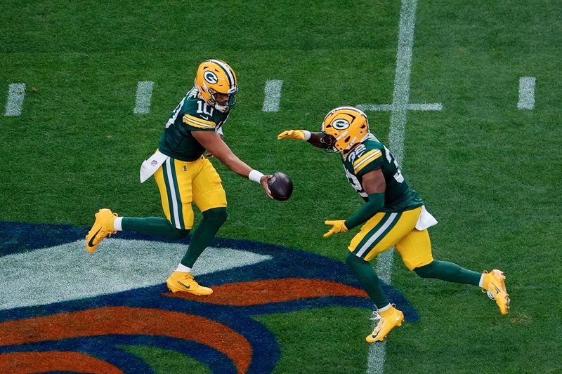 Packers quarterback Jordan Love (10) hands the ball off to running back Marshawn Lloyd (32) in the first quarter Aug. 21 against the Broncos at Empower Field at Mile High.
