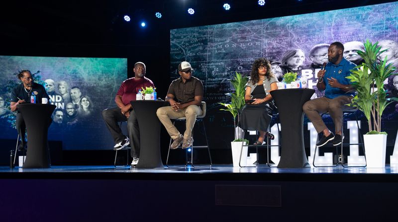 Theron Rogers Jr. speaks at the Behind the Gun event, a community-centered summit focused on firearm safety, responsible ownership, violence prevention, and community healing.  From left: James Causey, Pastor Kevin Simmons, Latrelle Johnson, Vee Taylor Tate and Theron Rogers, Jr. The event took place on Saturday August 22, at the Evolve Church in Milwaukee.