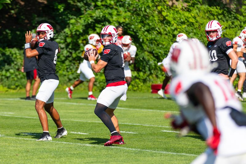Wisconsin quarterbacks Deuce Adams (8) and Colton Joseph (1) attempt passes during the Badgers' 15th practice of fall camp on the outdoor practice field near Camp Randall Stadium in Madison on Aug. 23, 2026.